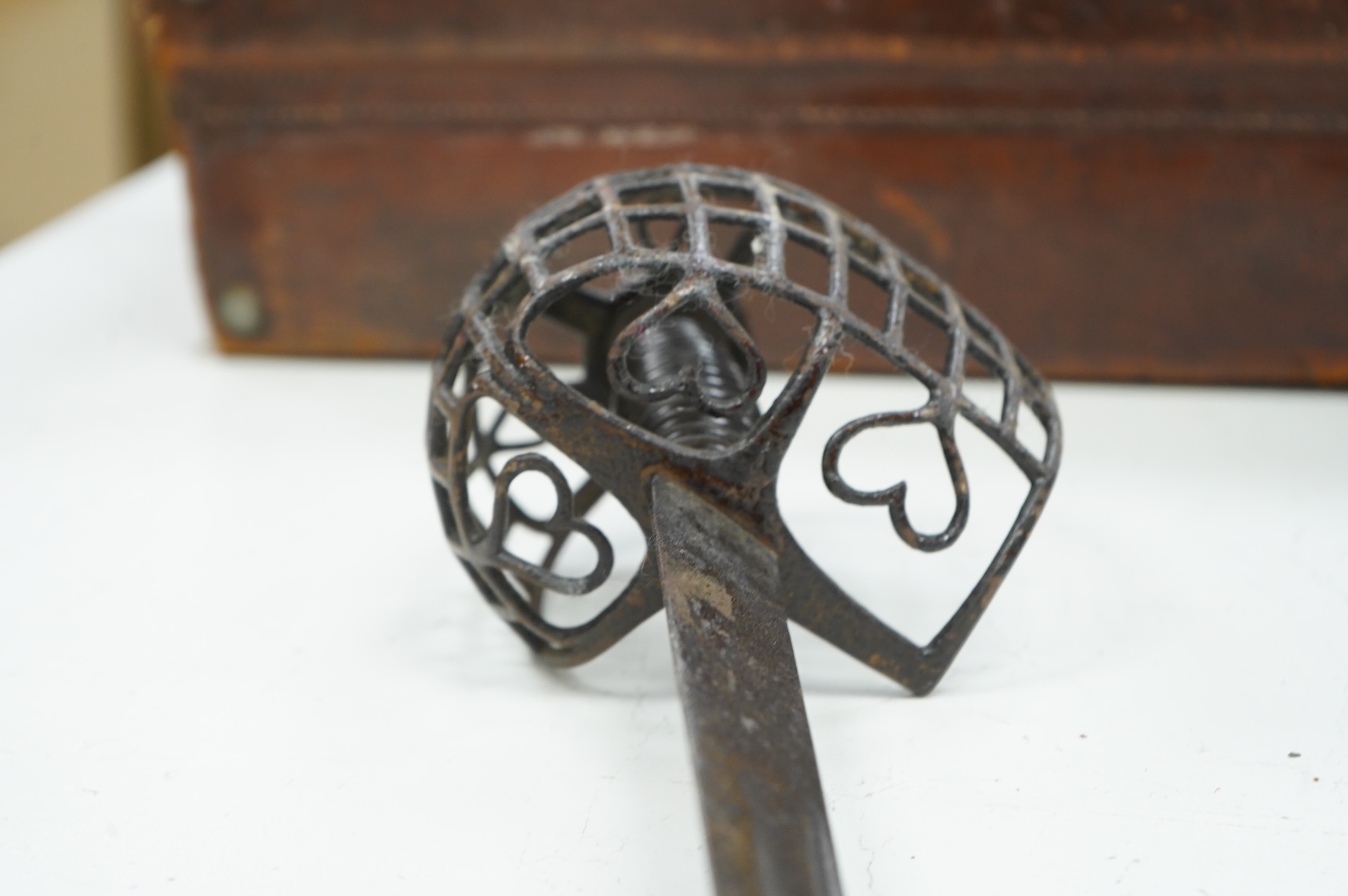 A basket hilted backsword of c.1750, with single edge blade cut with a pair of fullers, three-quarter basket guard comprising many rectangular openings, blade 90.5cm